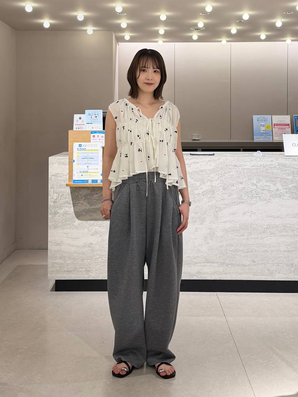 グレー系のスウェットパンツ、シルバー系のタンクトップ、ブラック系のサンダルを着用したレディースの夏コーディネートの1枚目の写真