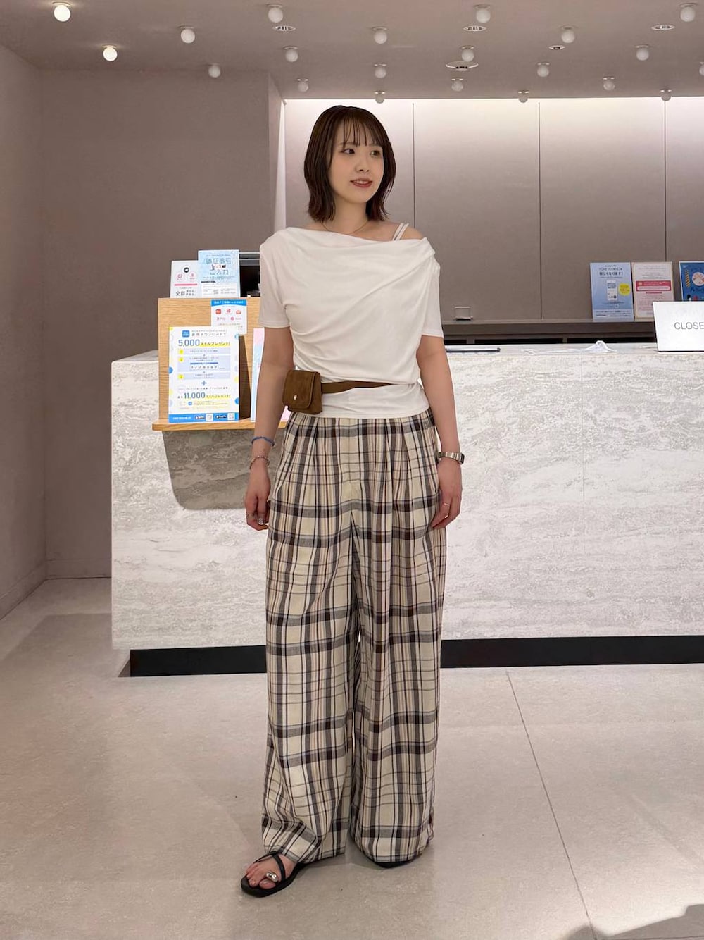 ホワイト系のTシャツ/カットソー、ベージュ系のスラックス、ブラック系のサンダルを着用したレディースの夏コーディネートの1枚目の写真
