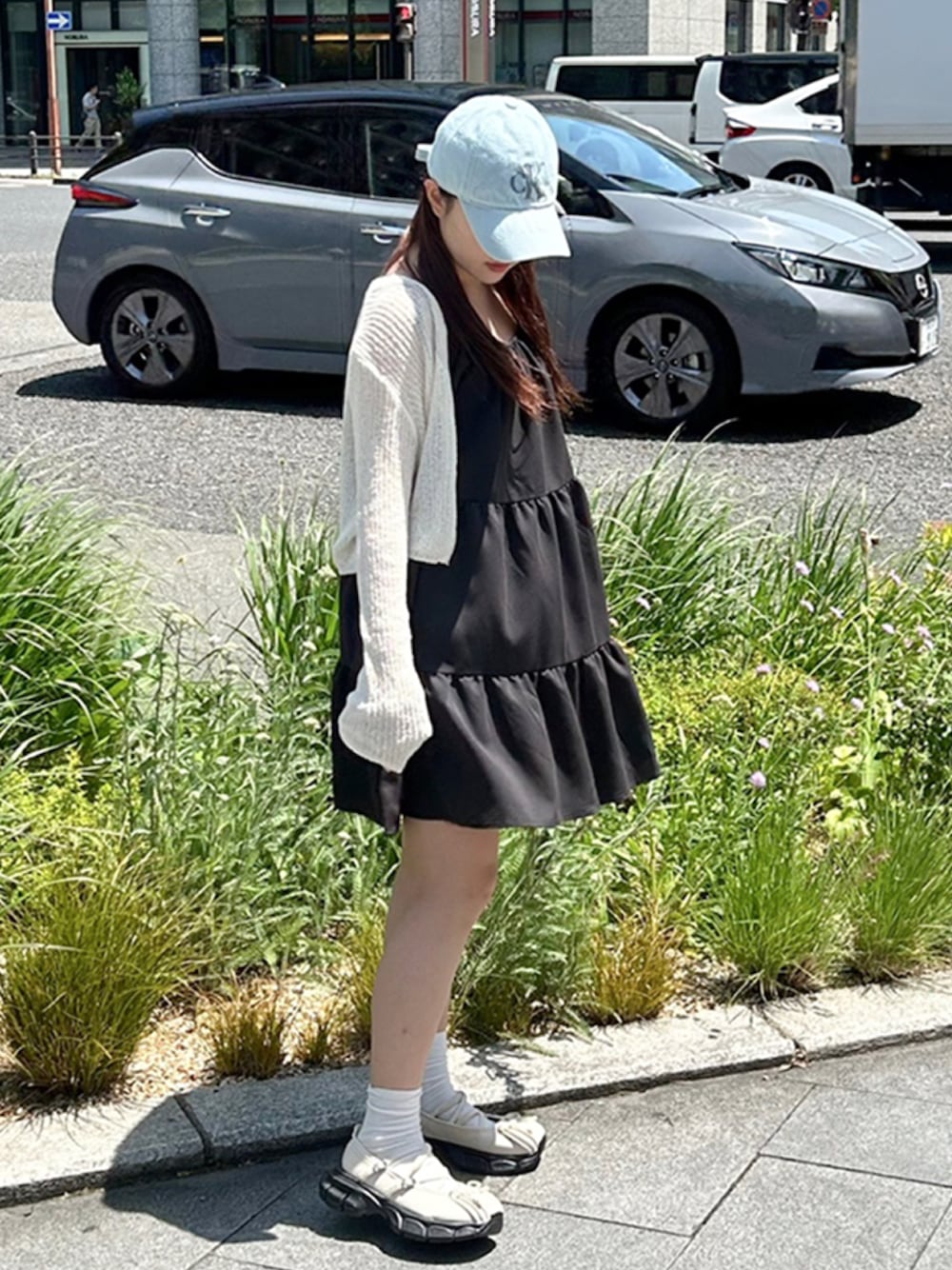 ブラック系のワンピース、ホワイト系のニット/セーター、ホワイト系のスニーカーを着用したレディースの夏コーディネートの1枚目の写真