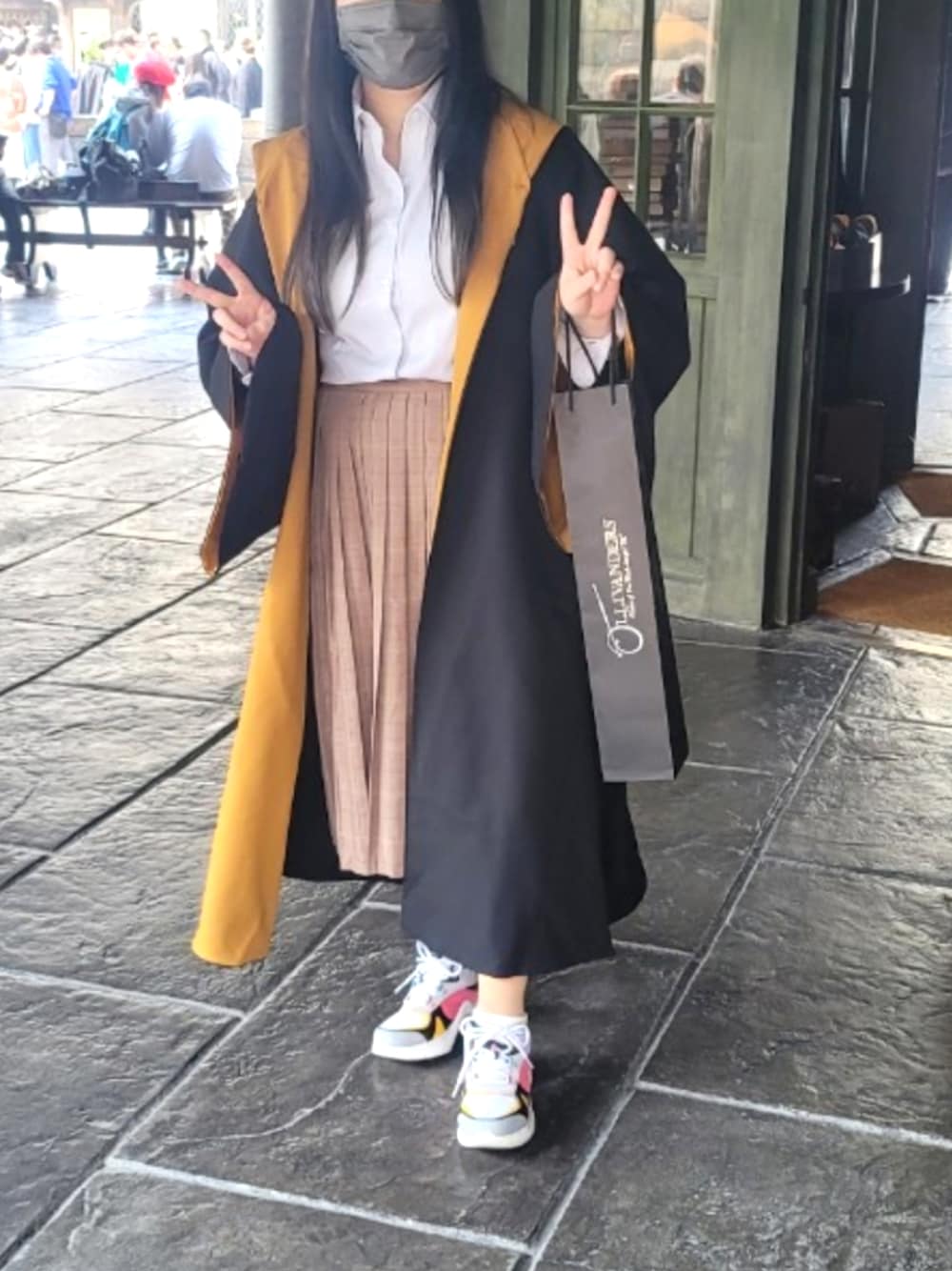 「春、春服デビュー宣言、スニーカー、USJ、ハッフルパフ、学生風、ユニバ、ユニバーサルスタジオジャパン、ひざ丈スカート、リュックスタイル、お出かけコーデ、ハリーポッター、ローブ」｜「ユニバーサルスタジオジャパンのアイテム（その他アウター、ブラック系）」を使った、NYANOさん（レディース・154cm）の春コーディネートの1枚目の写真