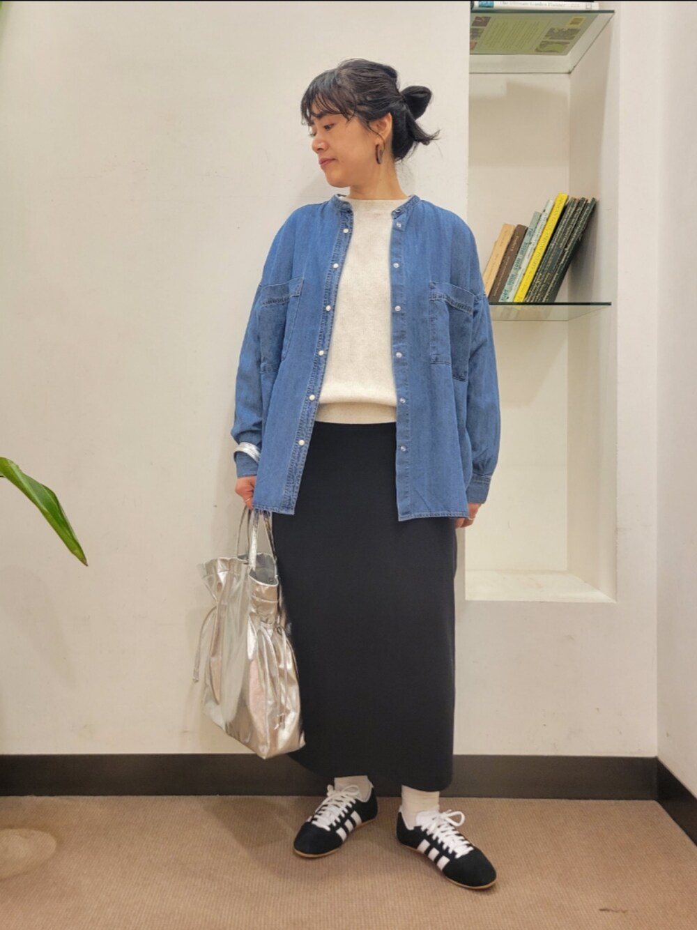 シルバー系のトートバッグ、ブルー系のシャツ/ブラウス、ブラック系のスカートを着用したレディースの冬コーディネートの1枚目の写真