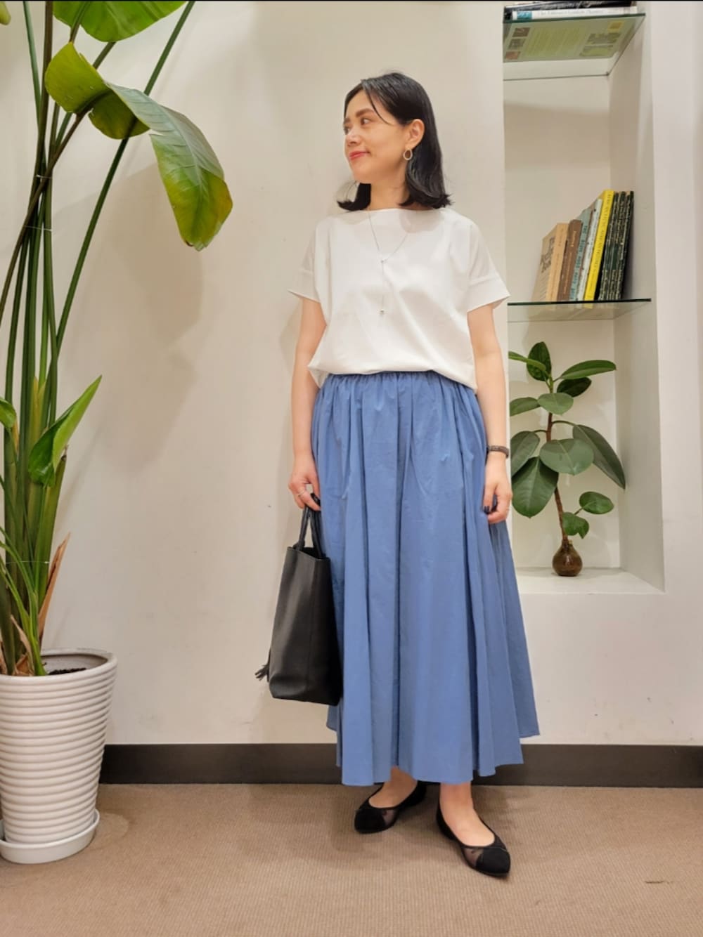 ブラック系のバレエシューズ、ブラック系のトートバッグ、ブルー系のスカートを着用したレディースの夏コーディネートの1枚目の写真