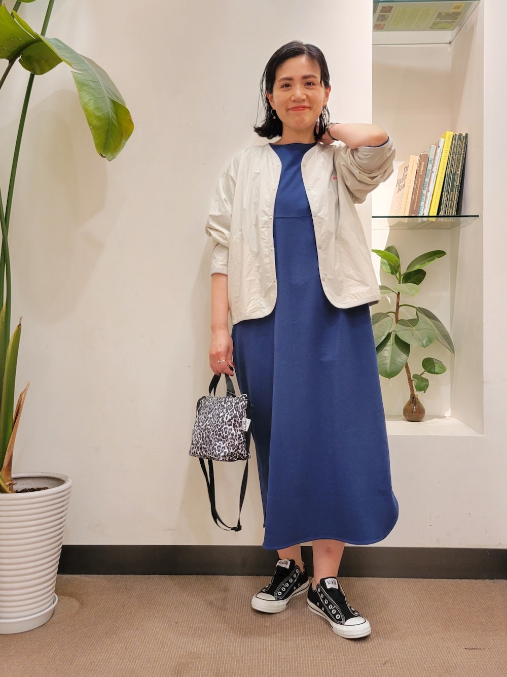 ホワイト系のショルダーバッグ、グレー系のノーカラージャケット、ブルー系のワンピースを着用したレディースの春コーディネートの1枚目の写真