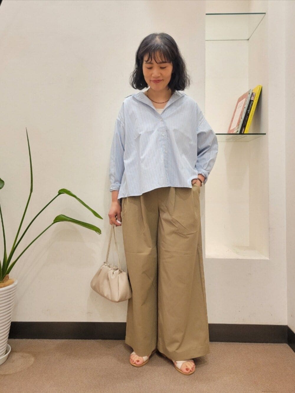 グレー系のショルダーバッグ、ベージュ系のその他パンツ、ブルー系のシャツ/ブラウスを着用したレディースの夏コーディネートの1枚目の写真