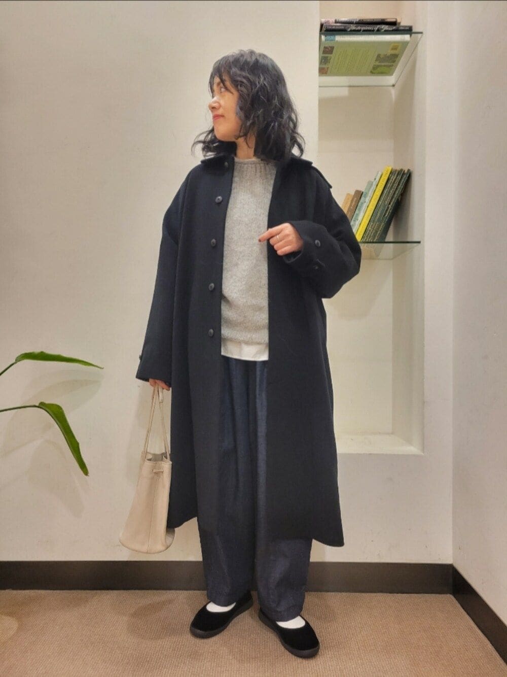 グレー系のショルダーバッグ、ブラック系のその他シューズ、ブルー系のデニムパンツを着用したレディースの秋コーディネートの1枚目の写真