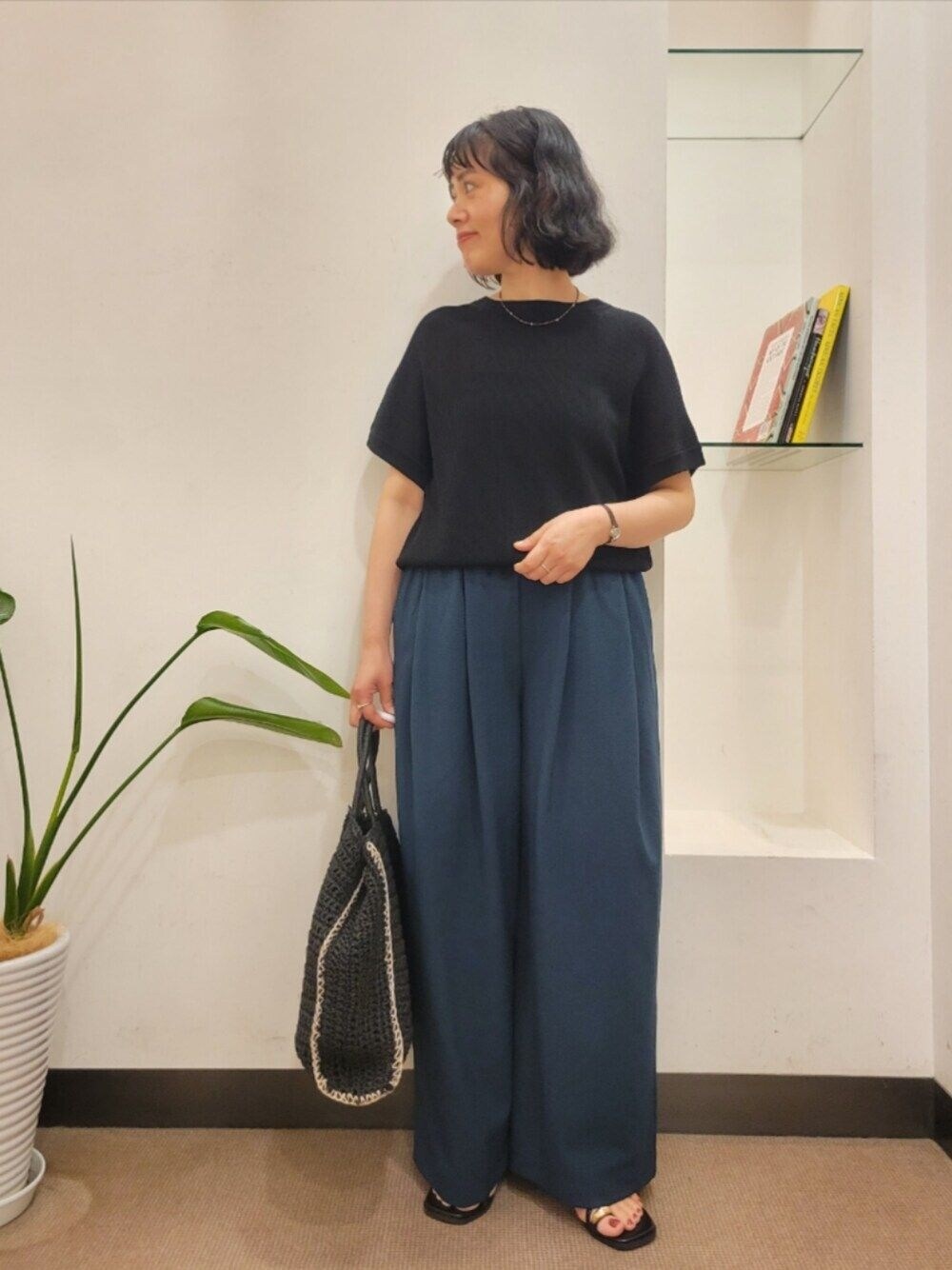 ブラック系のトートバッグ、グリーン系のその他パンツ、ブラック系のニット/セーターを着用したレディースの夏コーディネートの1枚目の写真