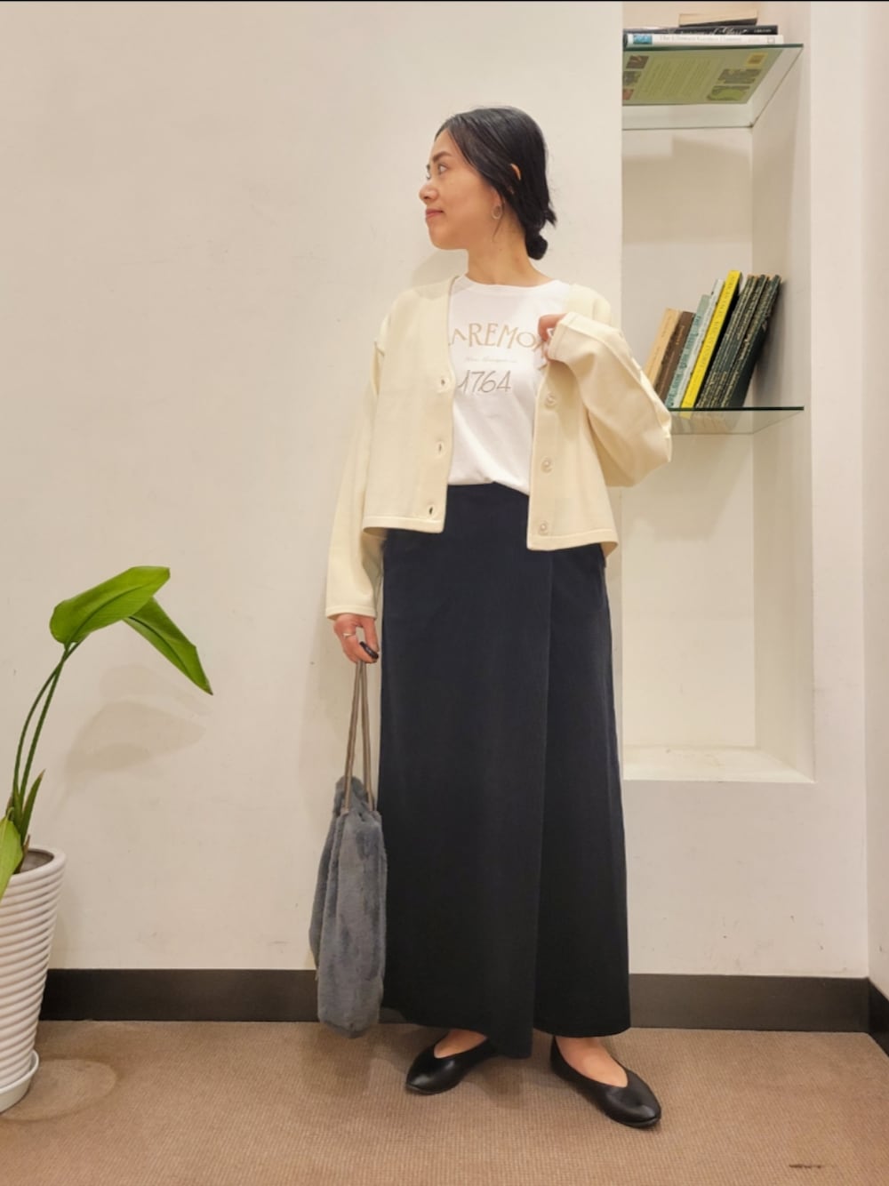 ブラック系のパンプス、グレー系のトートバッグ、ホワイト系のカーディガン/ボレロを着用したレディースの秋コーディネートの1枚目の写真