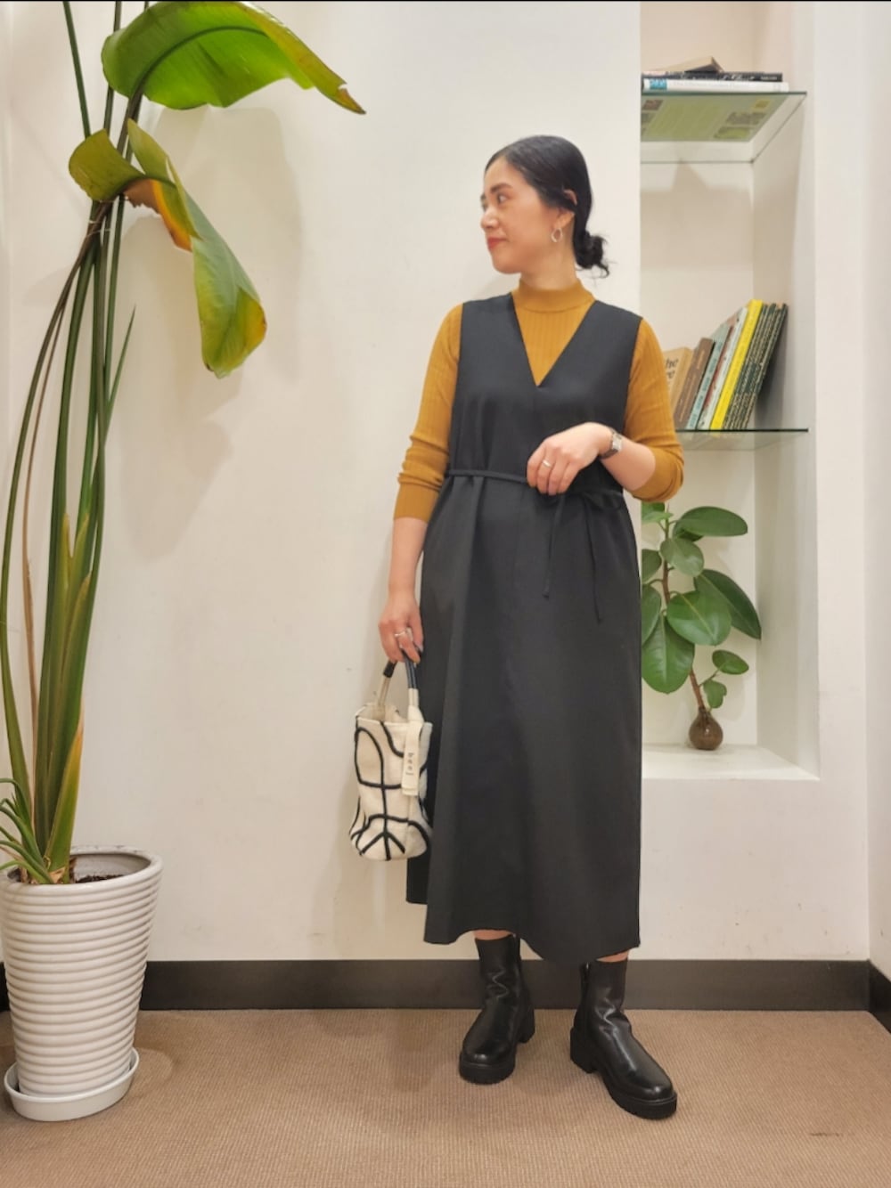 ホワイト系のショルダーバッグ、ブラック系のワンピース、イエロー系のニット/セーターを着用したレディースの秋コーディネートの1枚目の写真