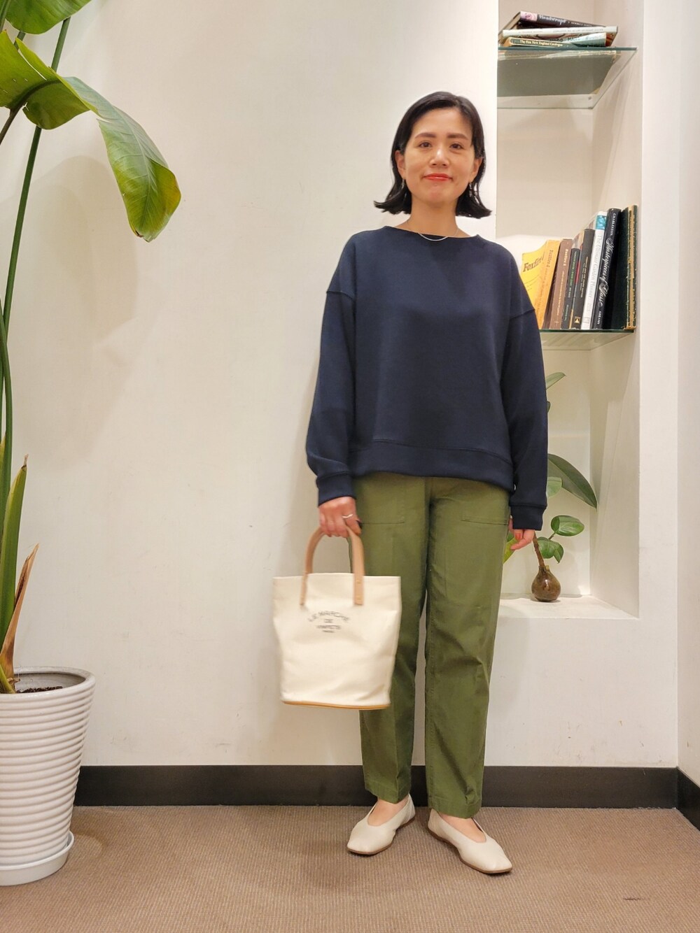 ホワイト系のトートバッグ、ベージュ系のパンプス、グリーン系のその他パンツを着用したレディースの春コーディネートの1枚目の写真