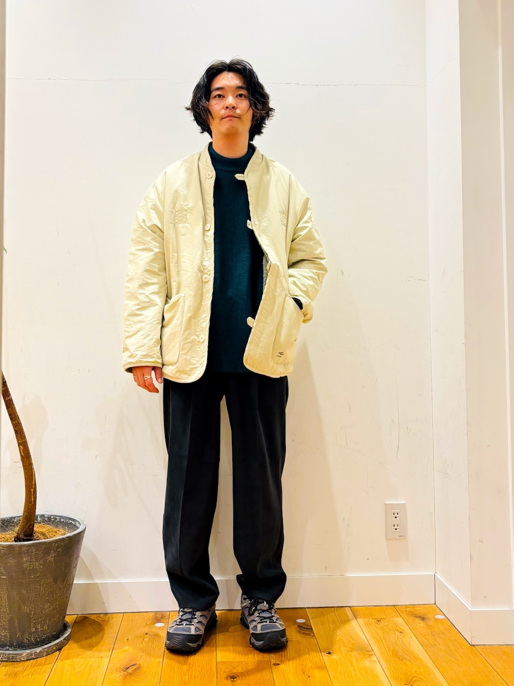 グリーン系のニット/セーター、ブラック系のその他パンツ、ホワイト系のその他アウターを着用したメンズの冬コーディネートの1枚目の写真