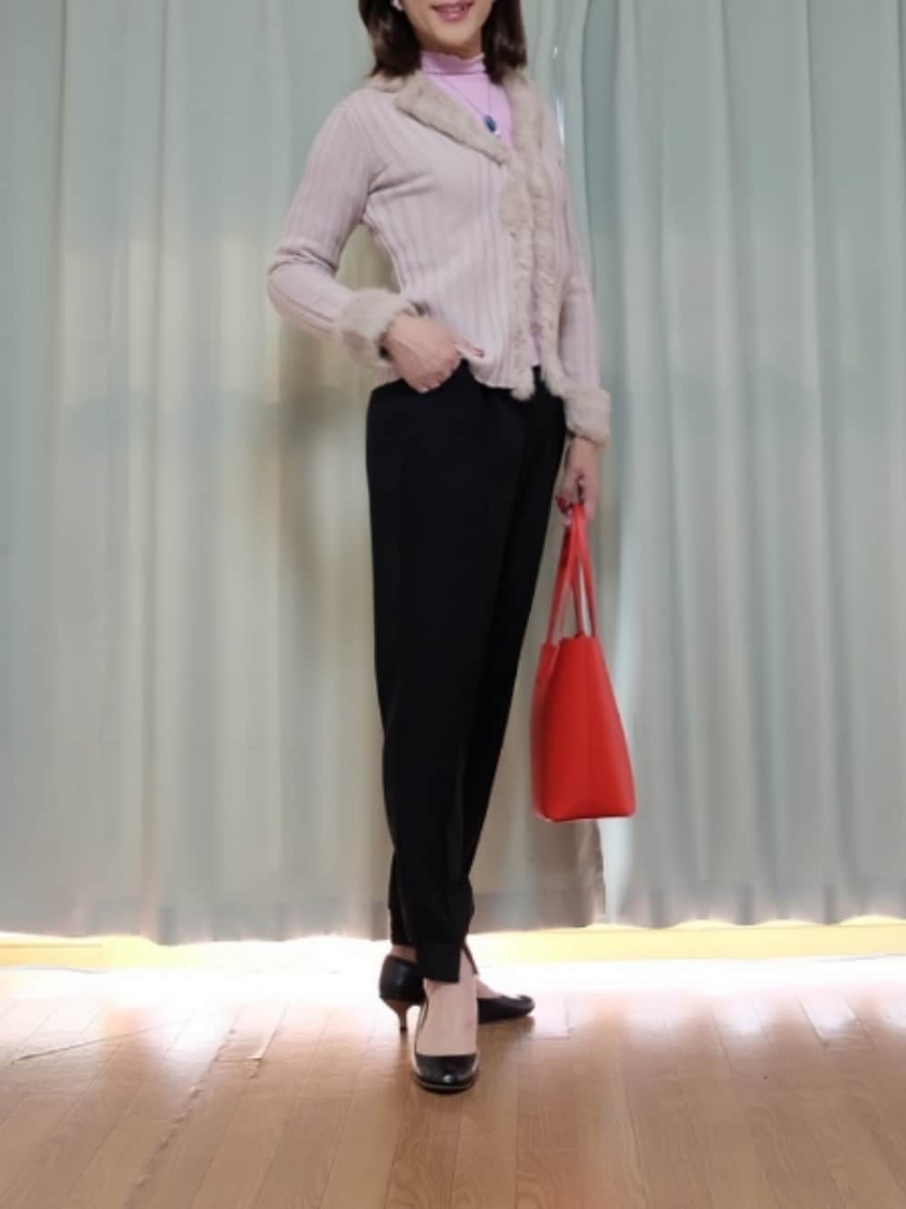 ブラック系のパンツ、ピンク系のカーディガン/ボレロを着用したレディースの春コーディネートの1枚目の写真