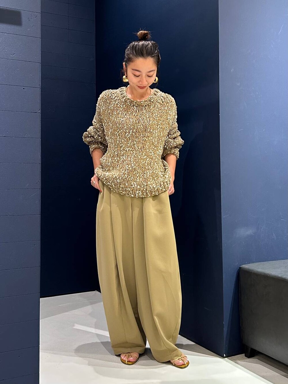 イエロー系のその他パンツ、ベージュ系のニット/セーター、ゴールド系のバングル/リストバンドを着用したレディースの夏コーディネートの1枚目の写真