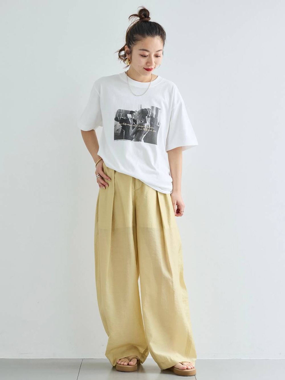 ベージュ系のその他パンツ、ホワイト系のTシャツ/カットソー、ゴールド系のバングル/リストバンドを着用したレディースの春コーディネートの1枚目の写真