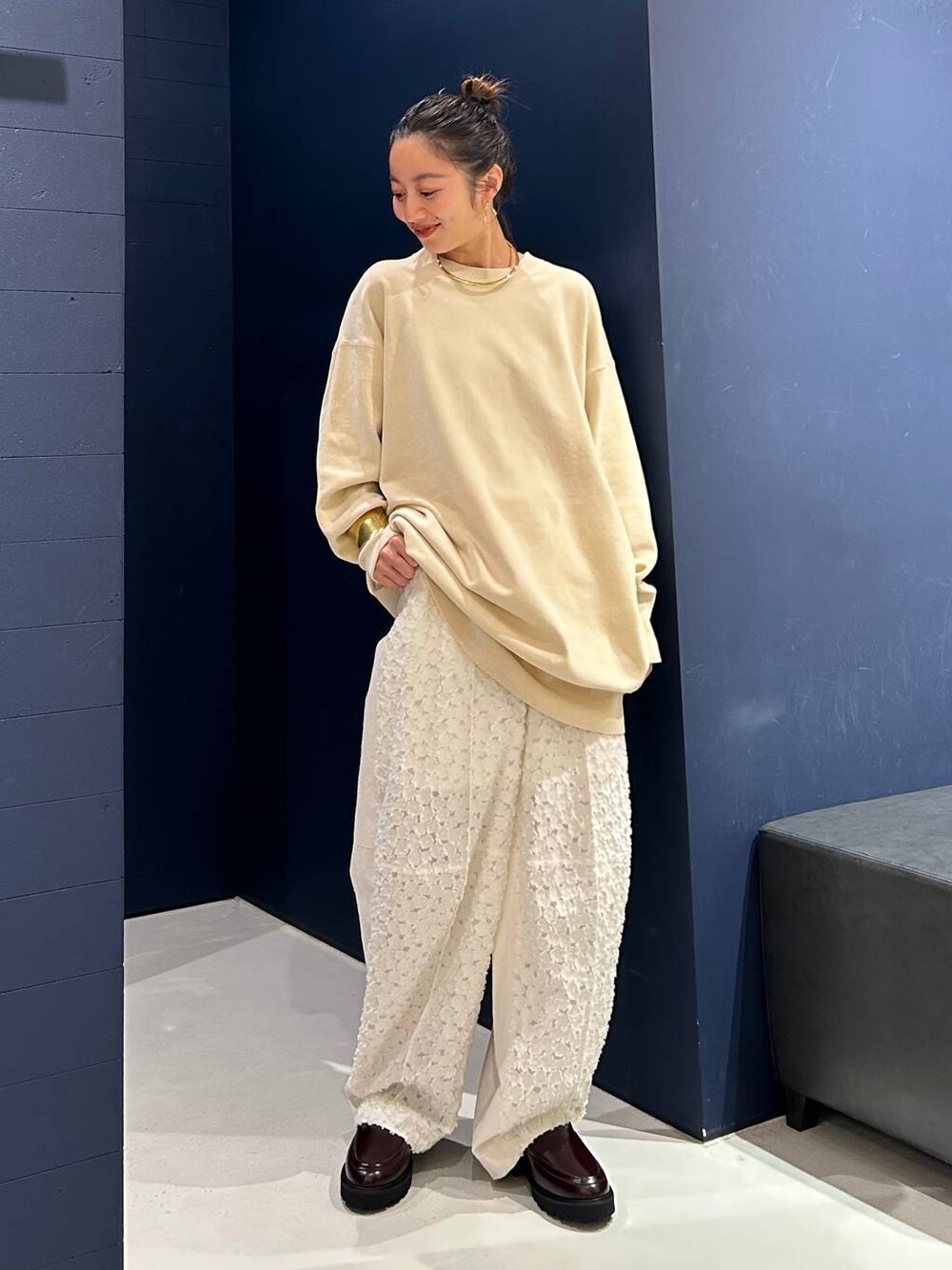 ホワイト系のその他パンツ、ホワイト系のニット/セーター、ゴールド系のバングル/リストバンドを着用したレディースの夏コーディネートの1枚目の写真