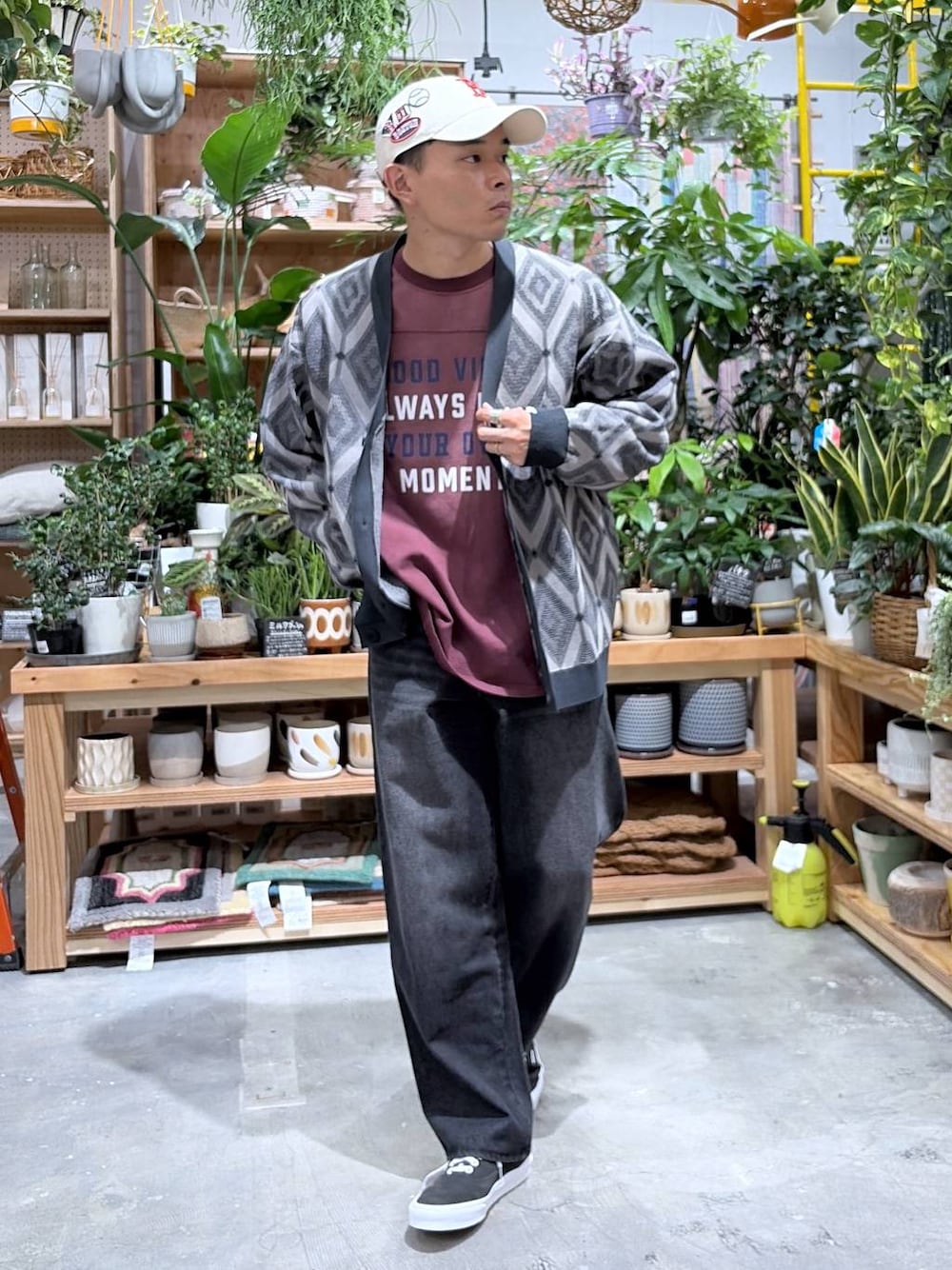 ブラック系のデニムパンツ、レッド系のTシャツ/カットソー、グレー系のカーディガン/ボレロを着用したメンズの秋コーディネートの1枚目の写真