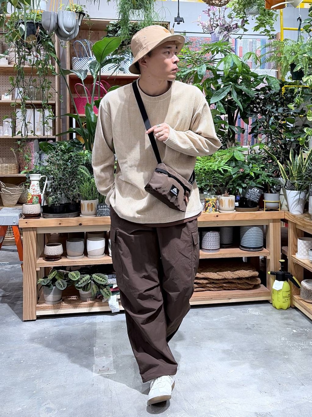 ベージュ系のTシャツ/カットソー、ブラウン系のカーゴパンツ、ベージュ系のハットを着用したメンズの秋コーディネートの1枚目の写真