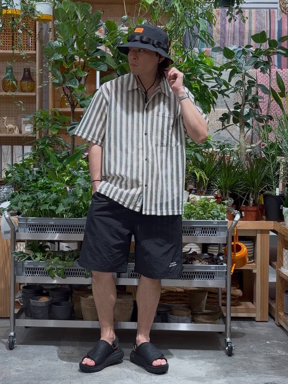 ブラック系のサンダル、ブラック系のその他パンツ、ホワイト系のタンクトップを着用したメンズの春コーディネートの1枚目の写真