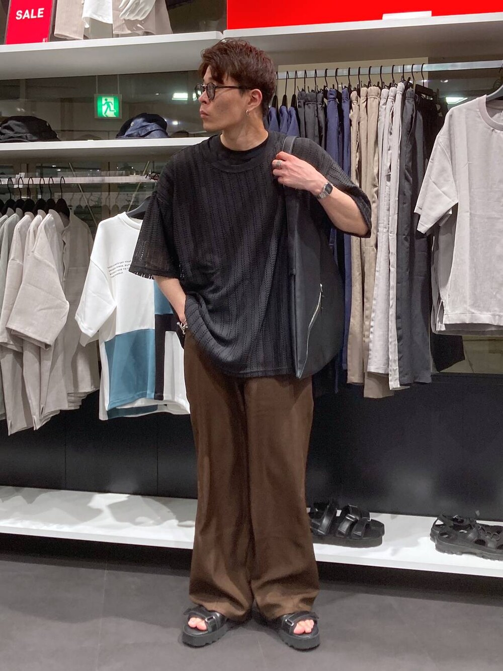 ブラック系のサンダル、ブラック系のTシャツ/カットソー、ブラック系のトートバッグを着用したメンズの夏コーディネートの1枚目の写真