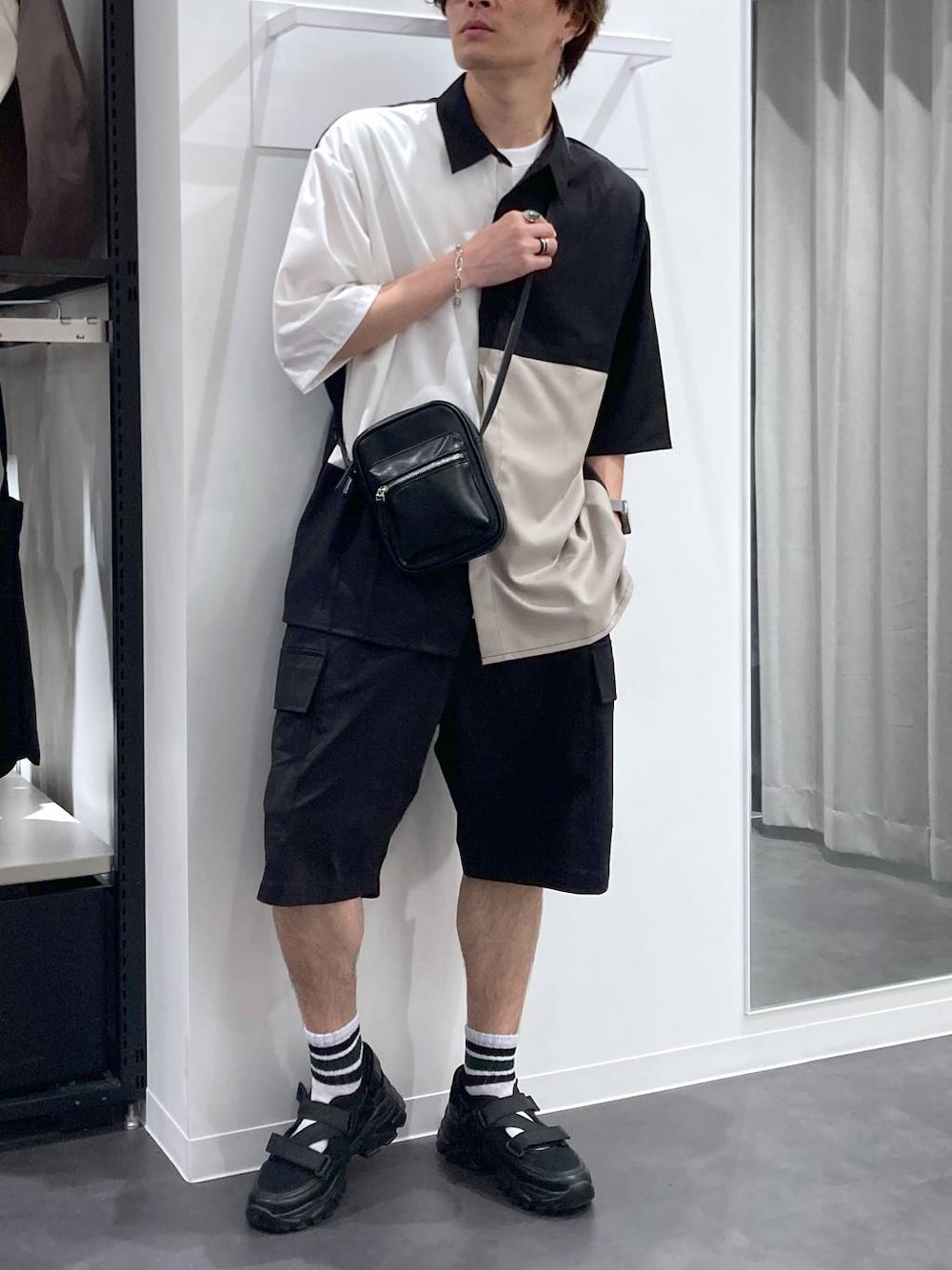 ブラック系のスニーカー、ホワイト系のTシャツ/カットソー、ブラック系のショルダーバッグを着用したメンズの夏コーディネートの1枚目の写真