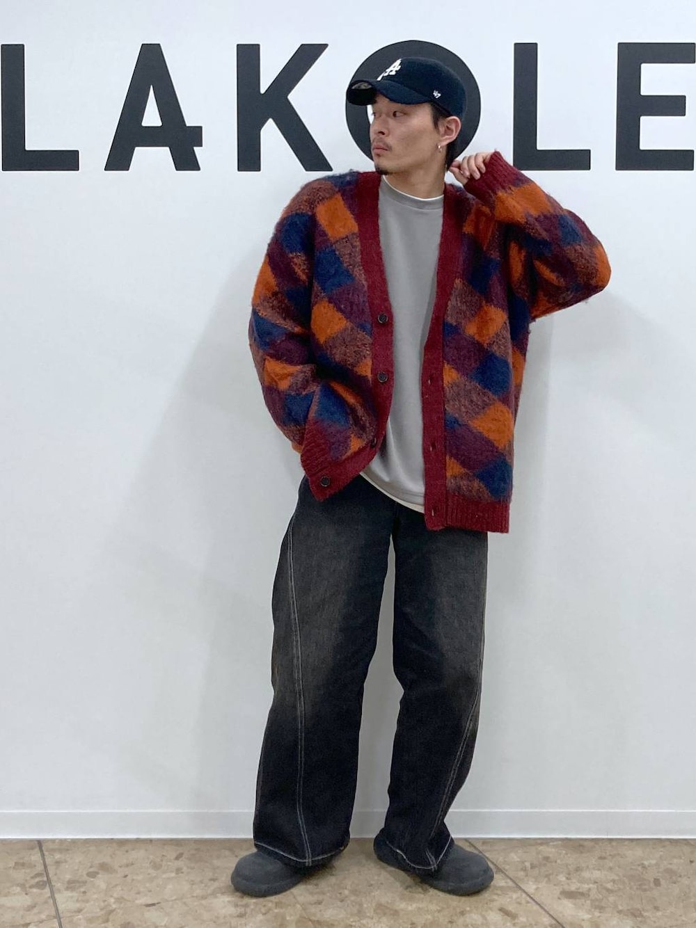 オレンジ系のカーディガン/ボレロ、グレー系のTシャツ/カットソー、ブラック系のデニムパンツを着用したメンズの冬コーディネートの1枚目の写真