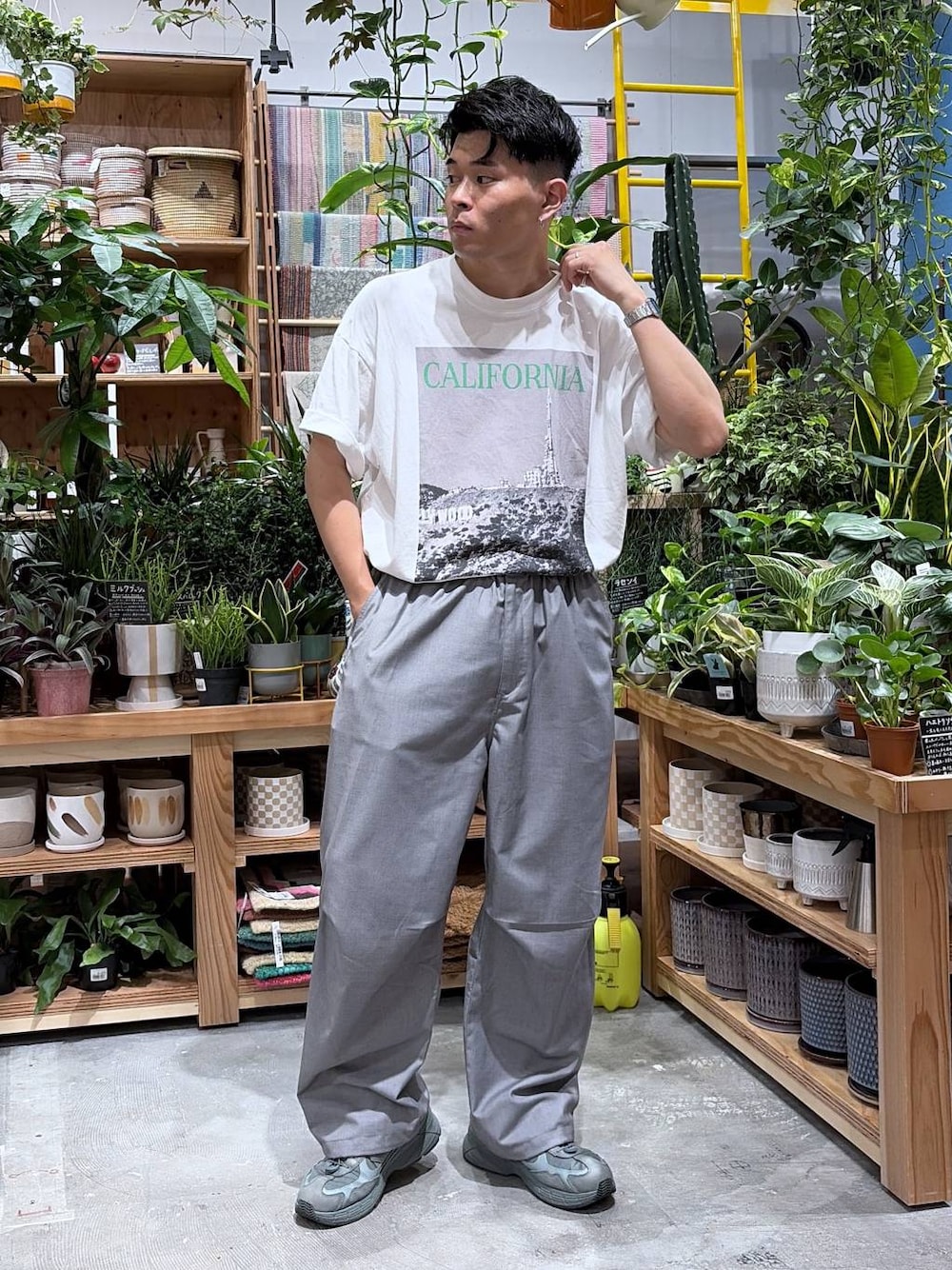 グレー系のスラックス、ホワイト系のTシャツ/カットソーを着用したメンズの夏コーディネートの1枚目の写真