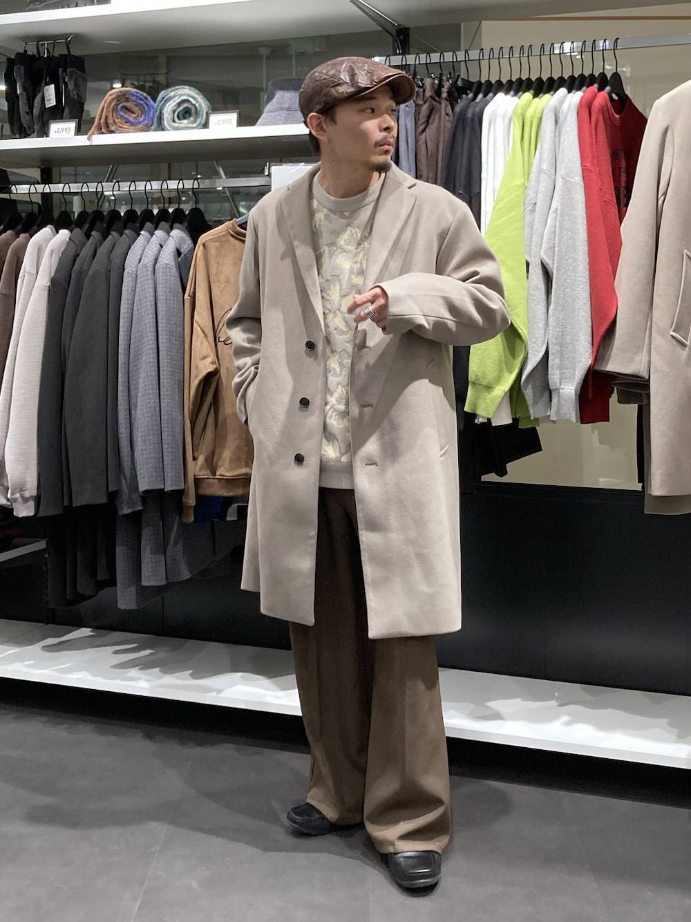 ホワイト系のチェスターコート、ベージュ系のニット/セーター、ブラウン系のその他パンツを着用したメンズの冬コーディネートの1枚目の写真