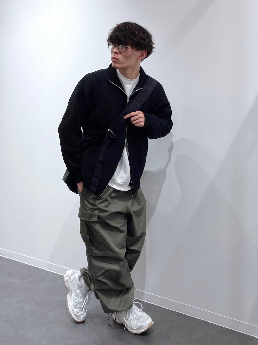 ホワイト系のスニーカー、ホワイト系のスウェット、グリーン系のカーゴパンツを着用したメンズの秋コーディネートの1枚目の写真