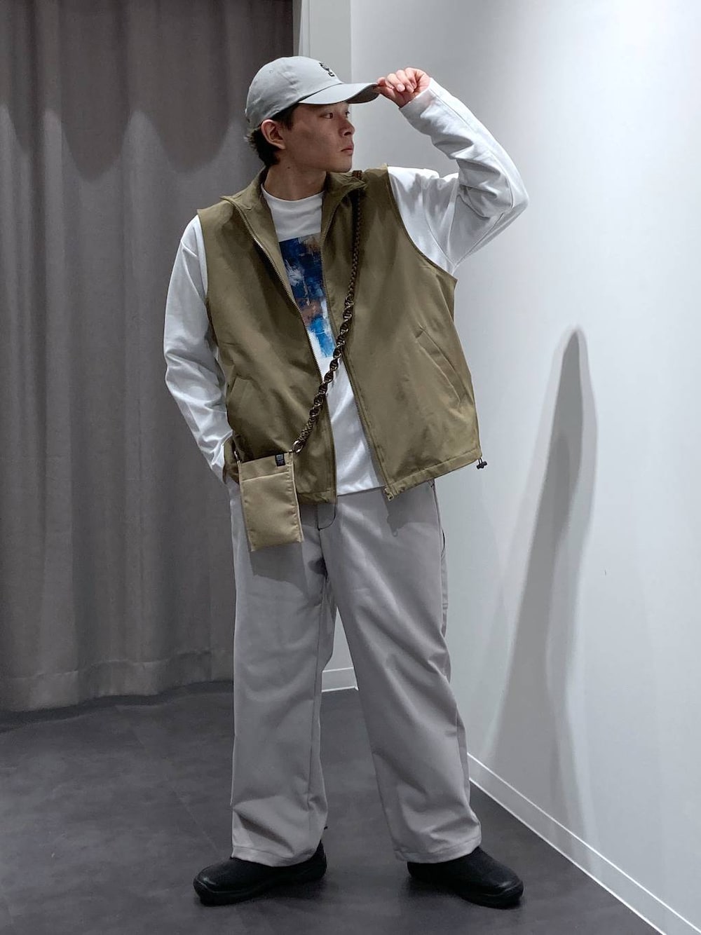 ベージュ系のベスト、グレー系のその他パンツ、ブラック系のスリッポンを着用したメンズの冬コーディネートの1枚目の写真