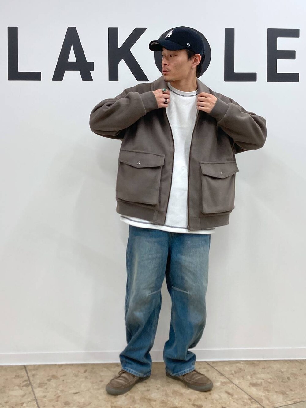 ブラウン系のブルゾン、ブルー系のデニムパンツ、ホワイト系のTシャツ/カットソーを着用したメンズの秋コーディネートの1枚目の写真