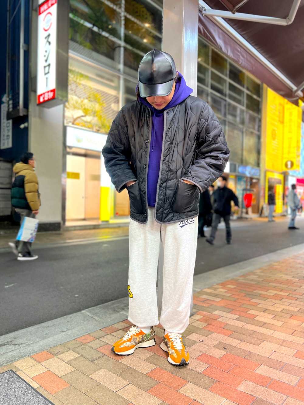 ブラック系のミリタリージャケット、パープル系のパーカー、ホワイト系のソックス/靴下を着用したメンズの春コーディネートの1枚目の写真