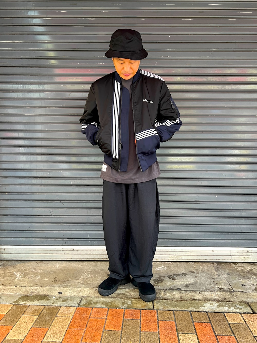 ブラック系のMA-1、グレー系のTシャツ/カットソー、ブラック系のブーツを着用したメンズの夏コーディネートの1枚目の写真