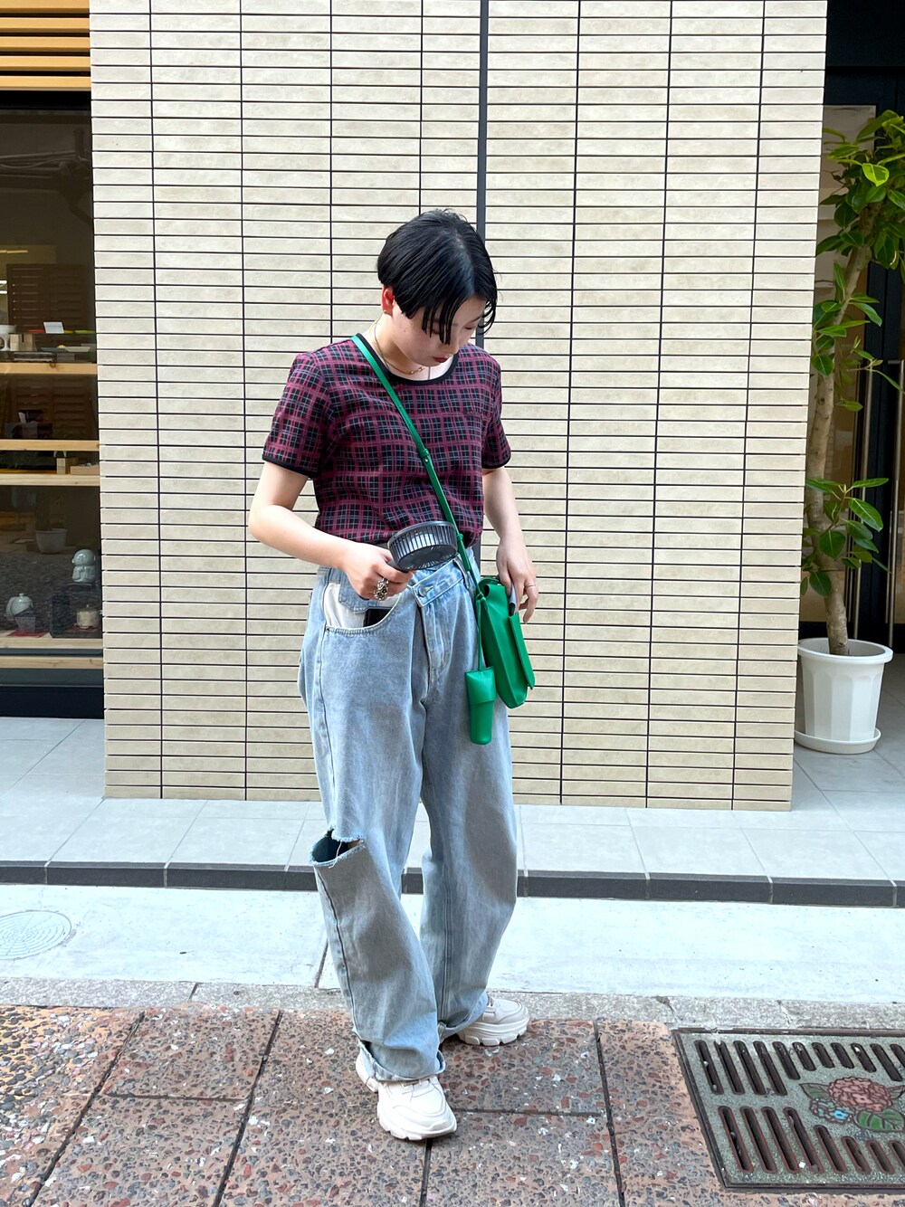 ブルー系のデニムパンツ、グリーン系のショルダーバッグ、パープル系のTシャツ/カットソーを着用したレディースの夏コーディネートの1枚目の写真