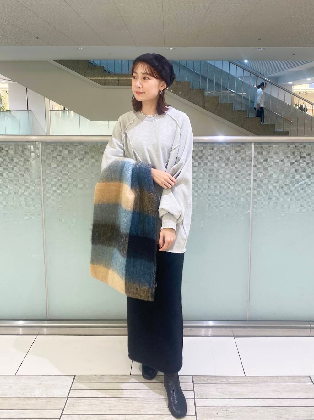 ブラック系のブーツ、ブラック系のスカート、グレー系のTシャツ/カットソーを着用したレディースの秋コーディネートの1枚目の写真