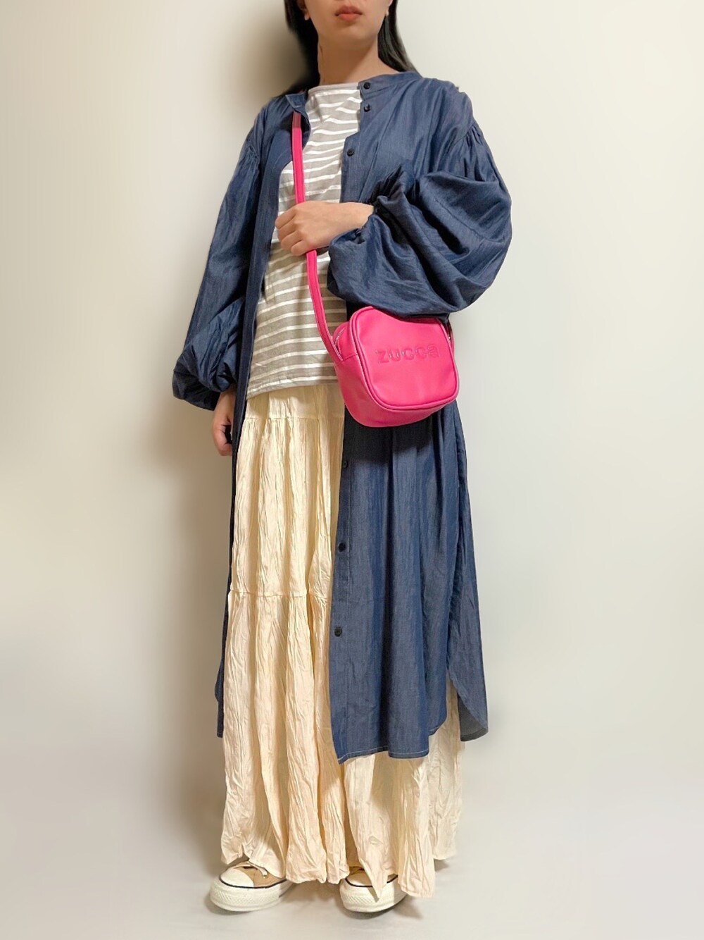 ブルー系のワンピース、ピンク系のショルダーバッグ、ホワイト系のスカートを着用したレディースの春コーディネートの1枚目の写真