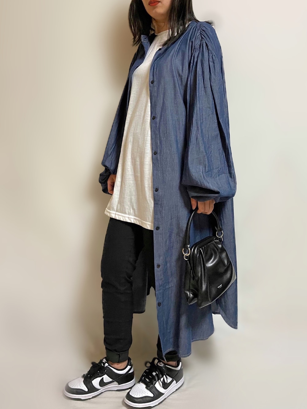 ブルー系のワンピース、グリーン系のベスト、ブラック系のパンツを着用したレディースの春コーディネートの1枚目の写真