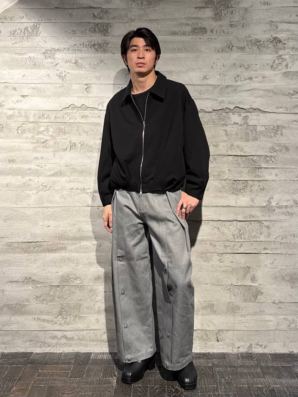 ブラック系のブーツ、ブラック系のブルゾン、グレー系のデニムパンツを着用したメンズの秋コーディネートの1枚目の写真