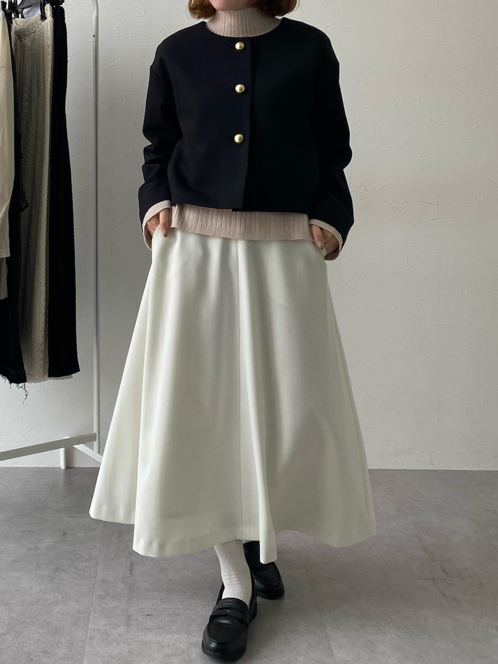 ベージュ系のニット/セーター、ブラック系のスーツセットを着用したレディースの秋コーディネートの1枚目の写真