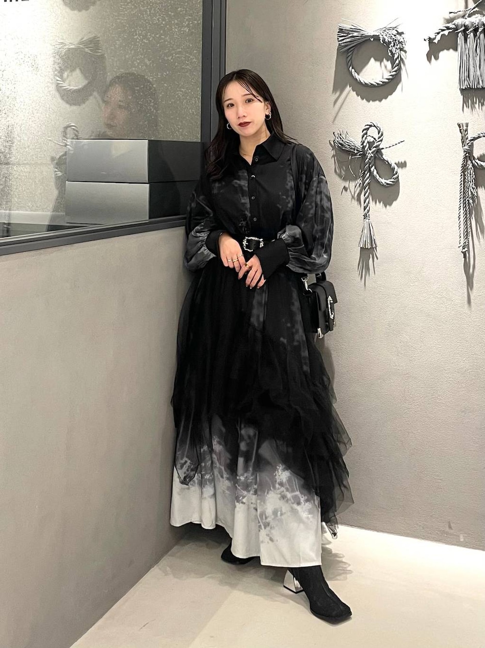 ブラック系のブーツ、ブラック系のショルダーバッグ、ブラック系のスカートを着用したレディースの冬コーディネートの1枚目の写真