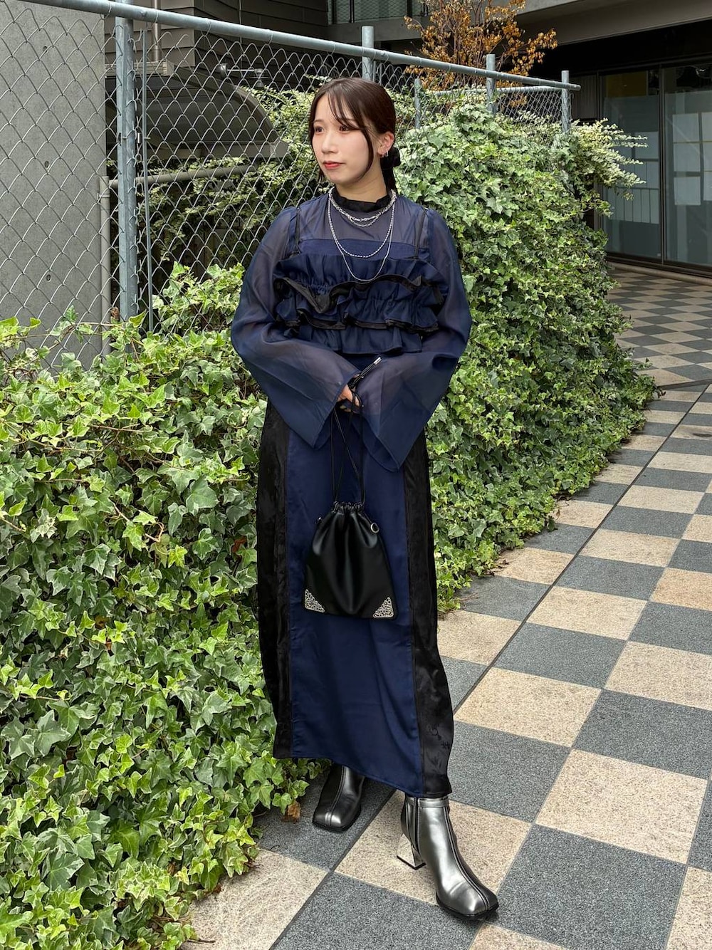 ブルー系のワンピース、ブラック系のトートバッグ、シルバー系のネックレスを着用したレディースの夏コーディネートの1枚目の写真