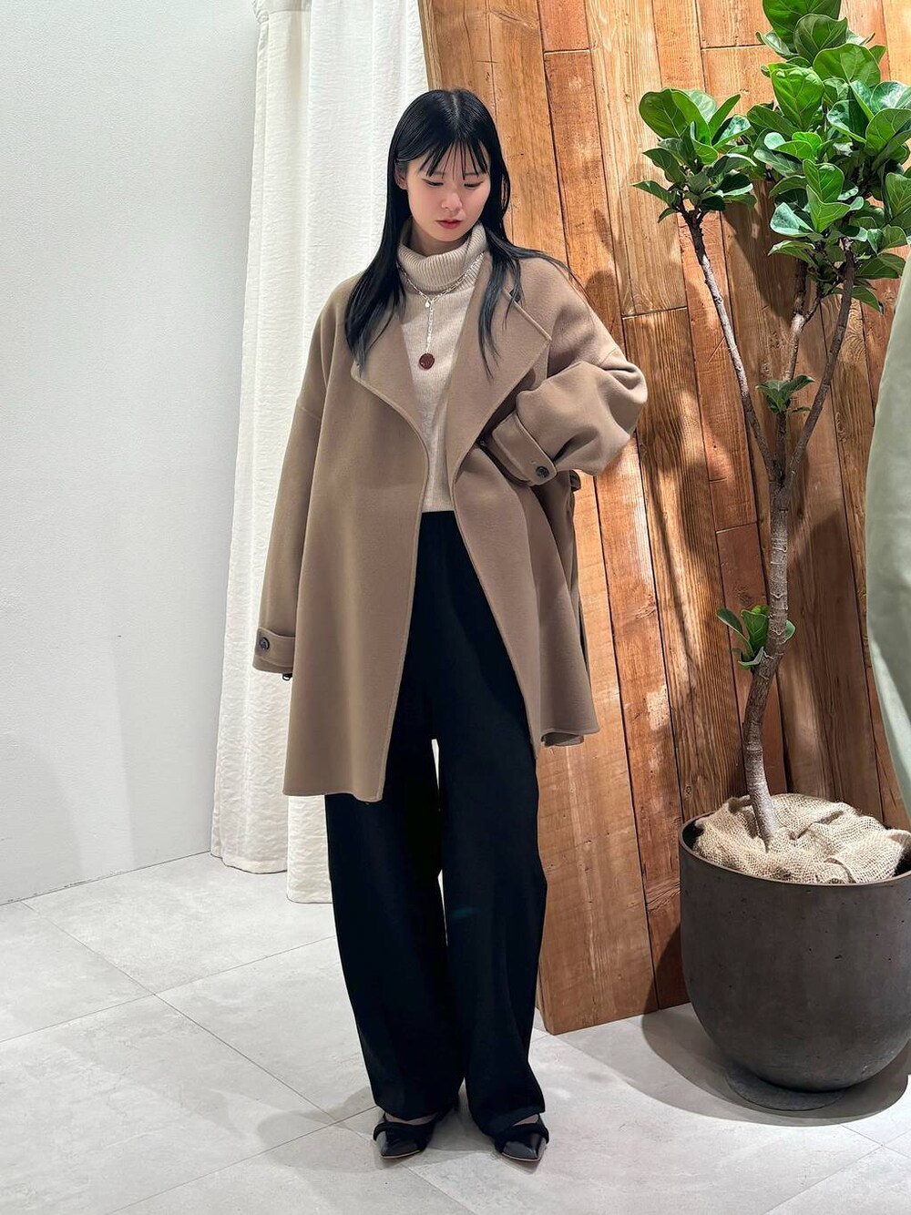 ベージュ系のニット/セーター、グレー系のピーコート、ブラック系のその他パンツを着用したレディースの秋コーディネートの1枚目の写真