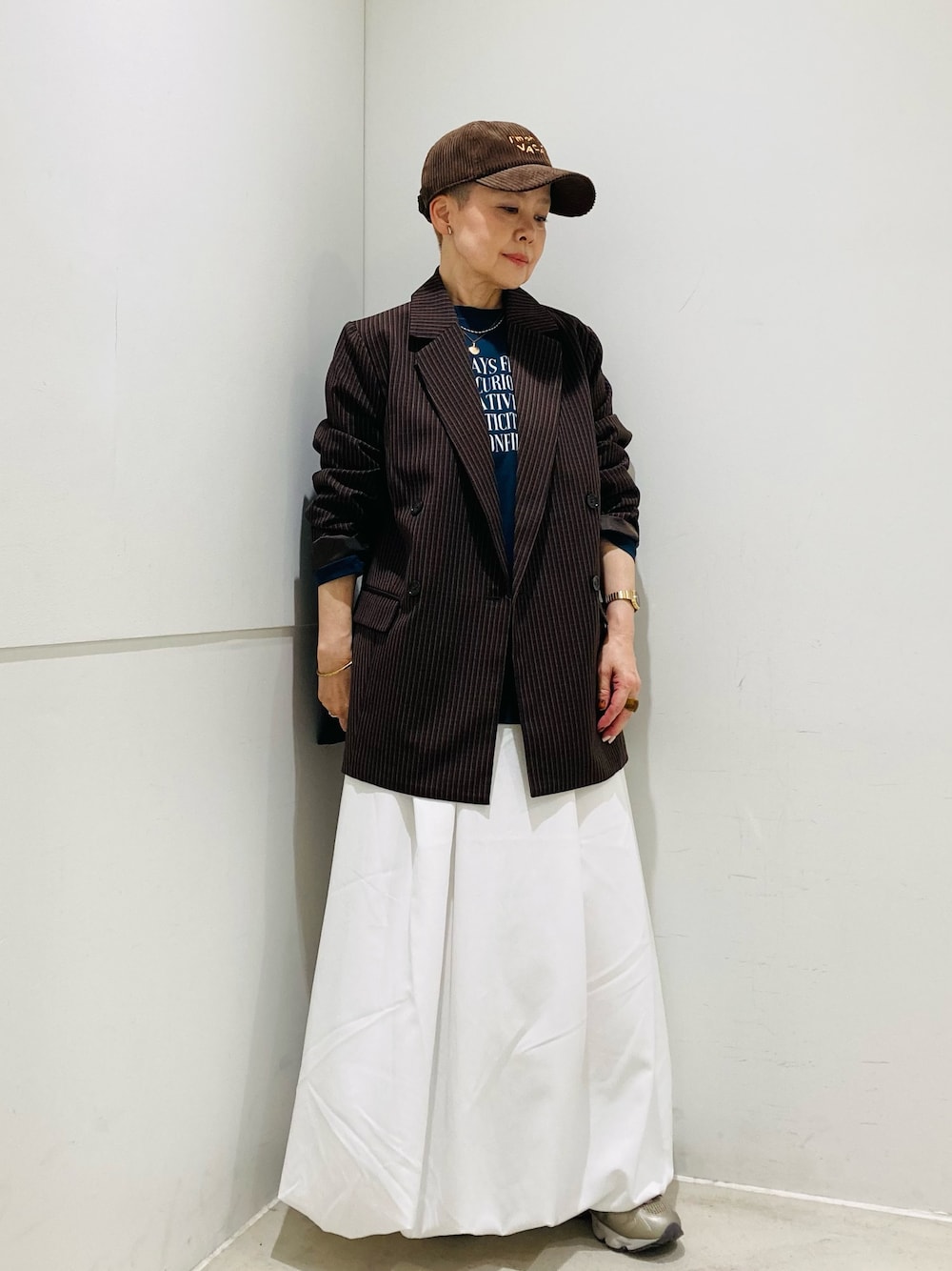 ホワイト系のスカート、ブラウン系のその他アウター、その他のTシャツ/カットソーを着用したレディースの秋コーディネートの1枚目の写真