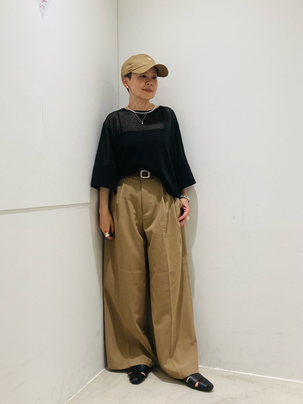 ベージュ系のその他パンツ、ブラック系のサンダル、ブラック系のニット/セーターを着用したレディースの春コーディネートの1枚目の写真