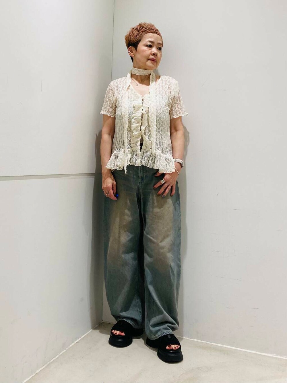 ブラウン系のデニムパンツ、ブラック系のサンダル、グレー系のキャミソールを着用したレディースの夏コーディネートの1枚目の写真