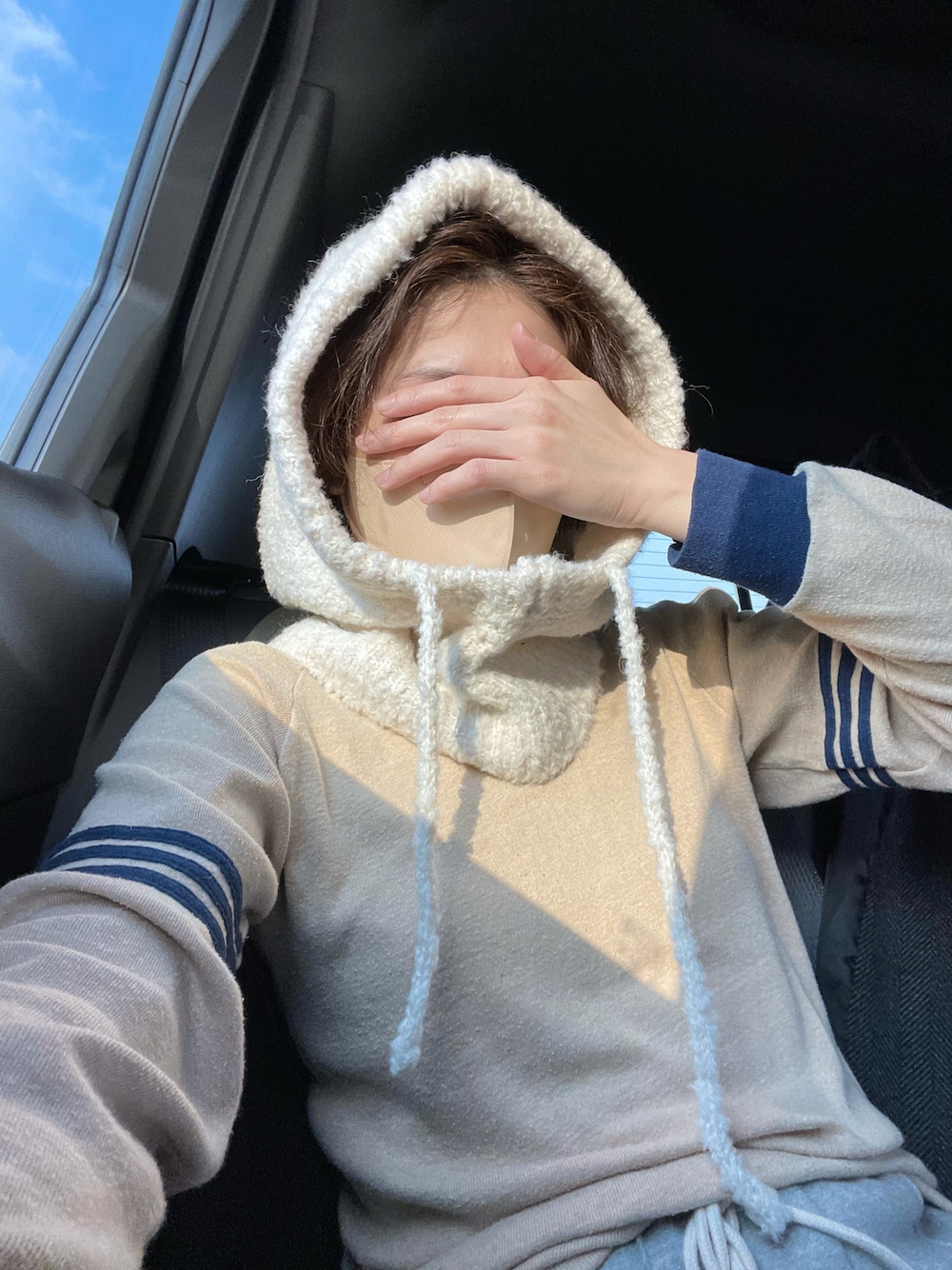 グレー系のスウェットパンツ、ホワイト系のニットキャップ/ビーニーを着用したレディースの冬コーディネートの1枚目の写真