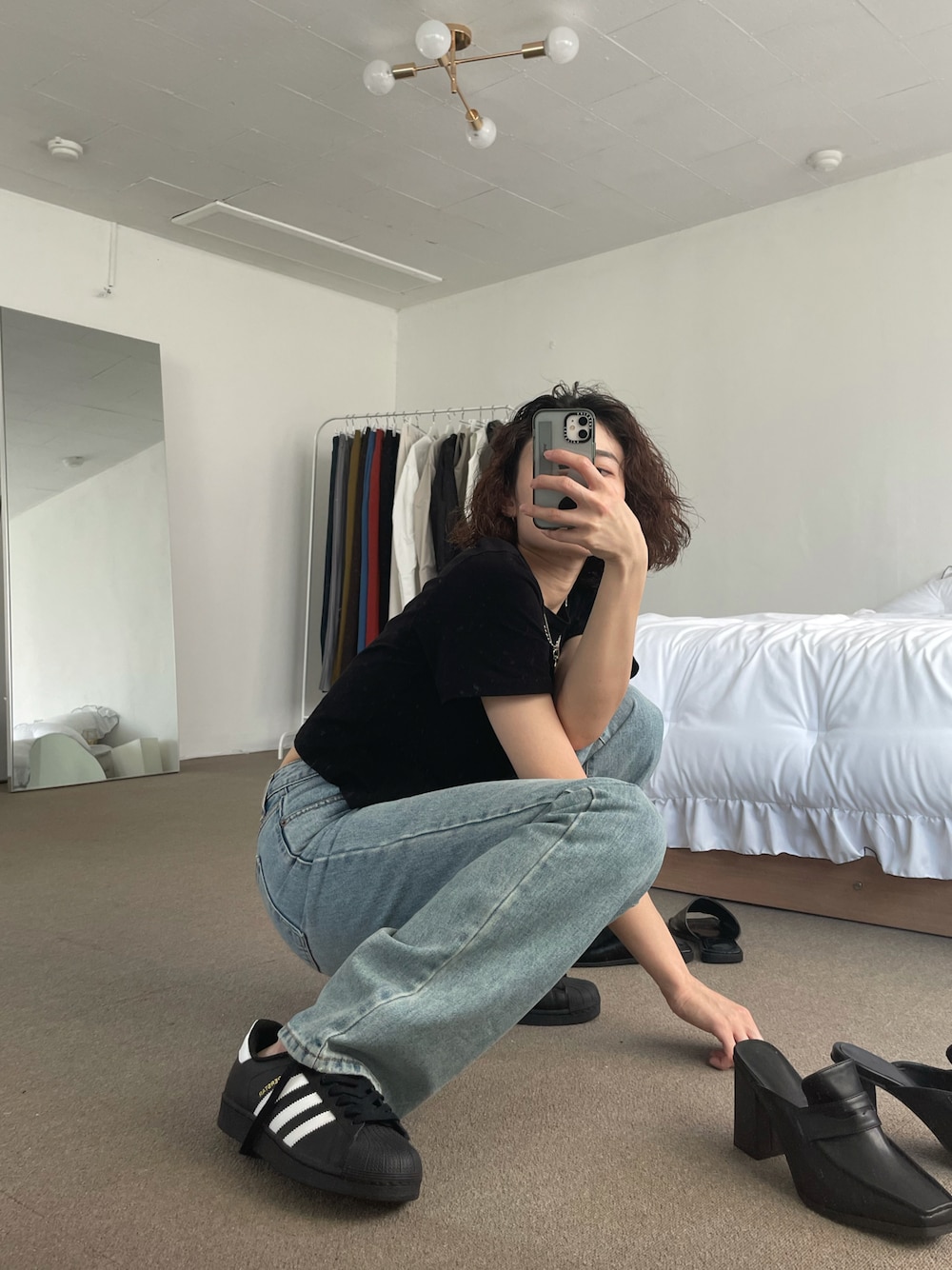 ブルー系のデニムパンツ、ブラック系のスニーカー、ブラック系のローファーを着用したレディースの秋コーディネートの1枚目の写真