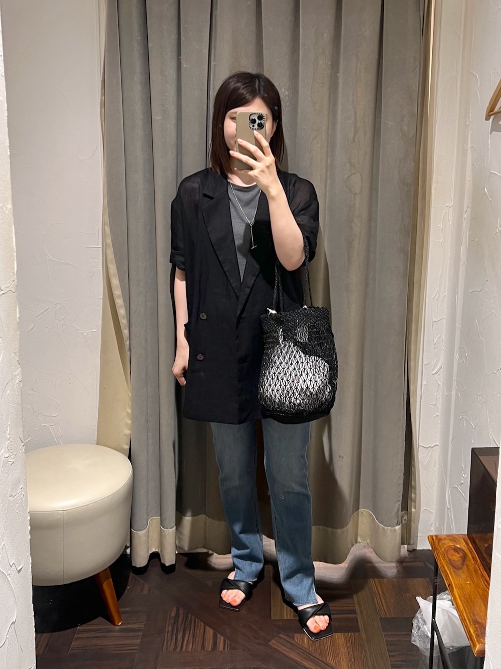 ブラック系のテーラードジャケット、ブルー系のデニムパンツ、ブラック系のサンダルを着用したレディースの夏コーディネートの1枚目の写真