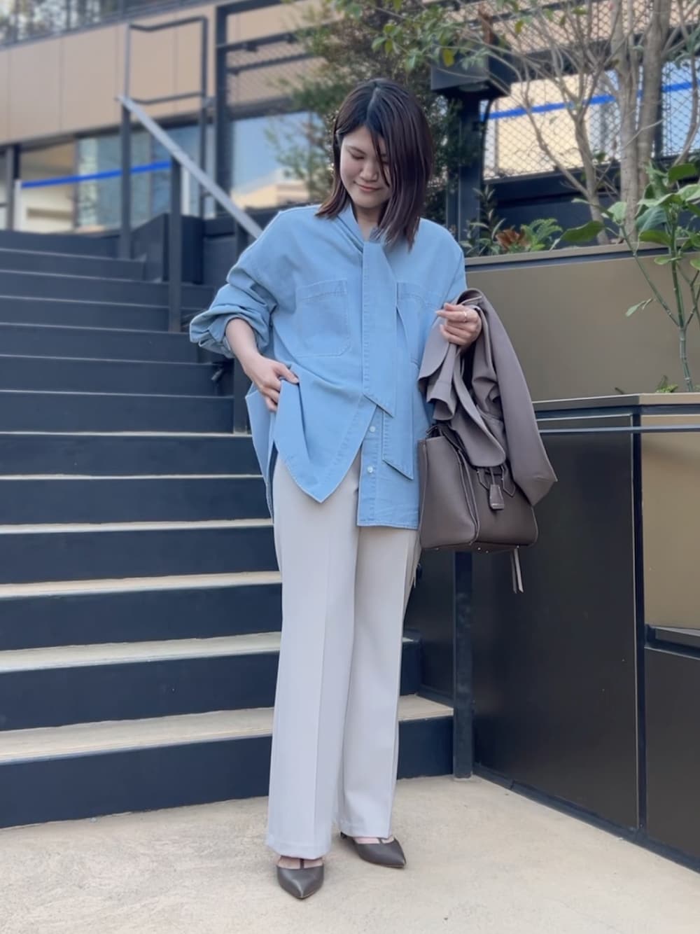 ブルー系のシャツ/ブラウス、ブラウン系のトートバッグ、ベージュ系のその他パンツを着用したレディースの冬コーディネートの1枚目の写真