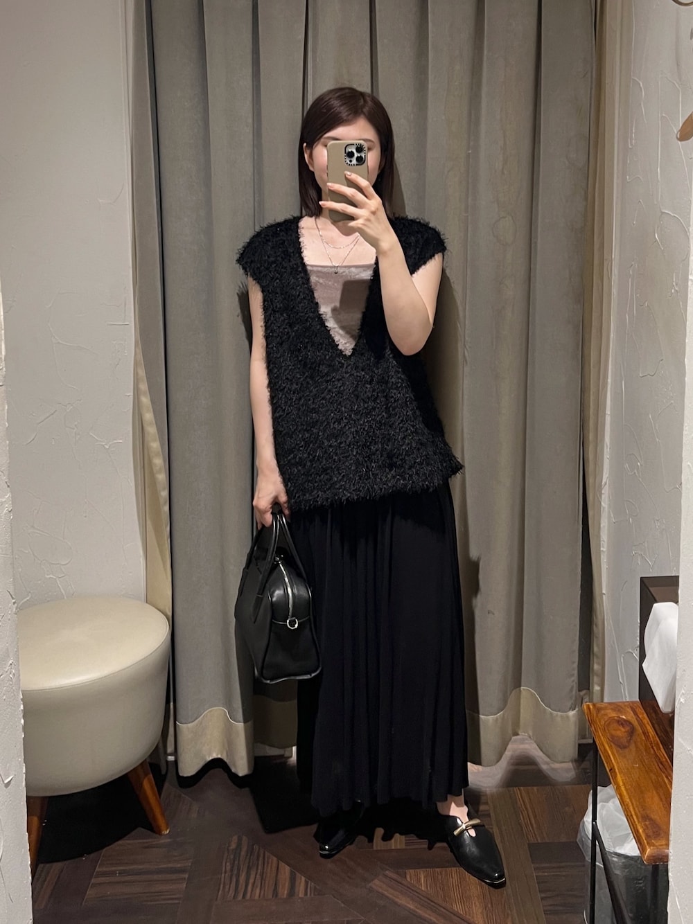 ブラック系のベスト、ブラック系のスカート、ブラック系のボストンバッグを着用したレディースの夏コーディネートの1枚目の写真