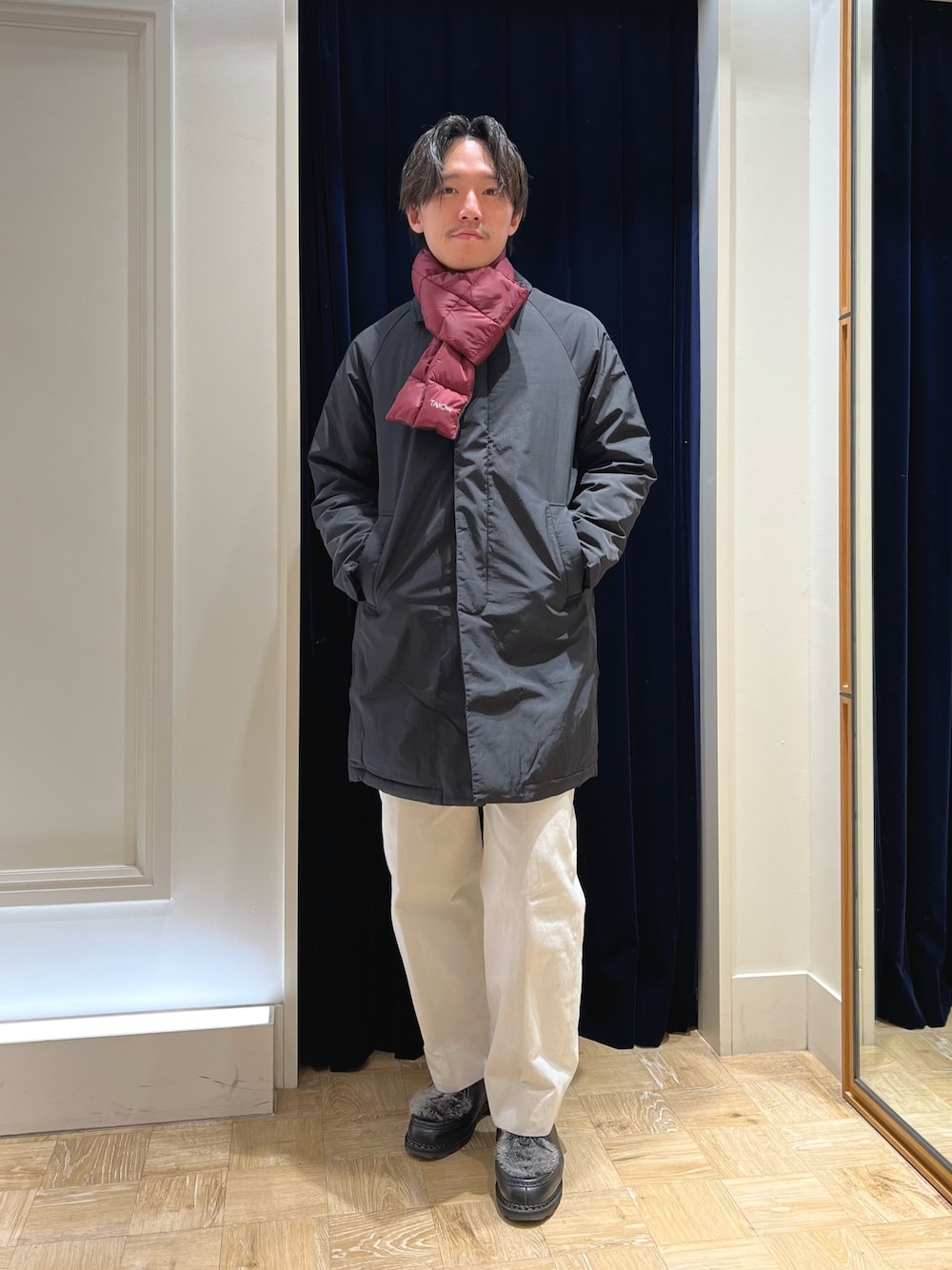 ブラック系のダウンジャケット/コート、ブラック系のシューズ、レッド系のマフラーを着用したメンズの冬コーディネートの1枚目の写真