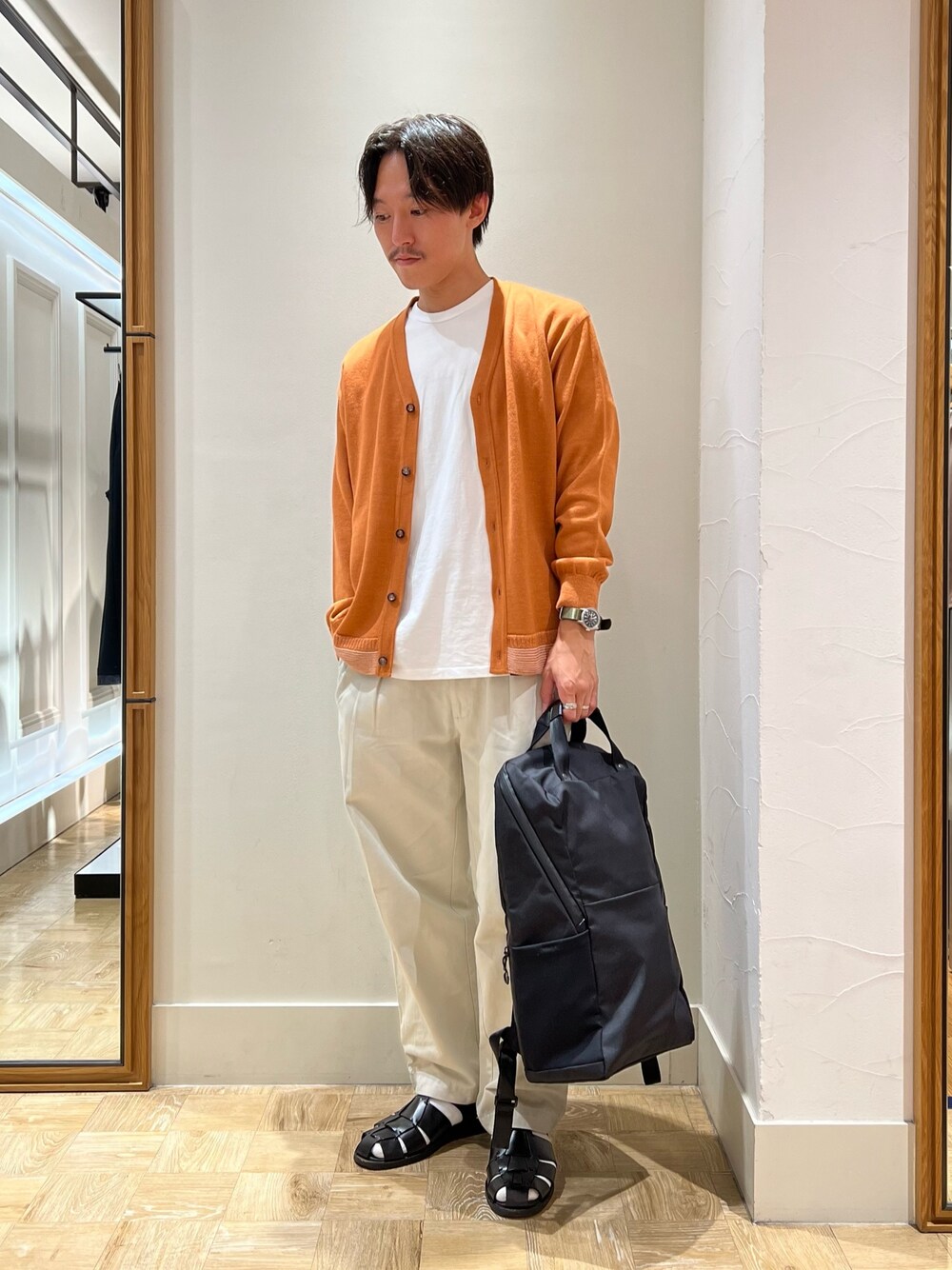 イエロー系のカーディガン/ボレロ、ブラック系のバックパック/リュックを着用したメンズの秋コーディネートの1枚目の写真